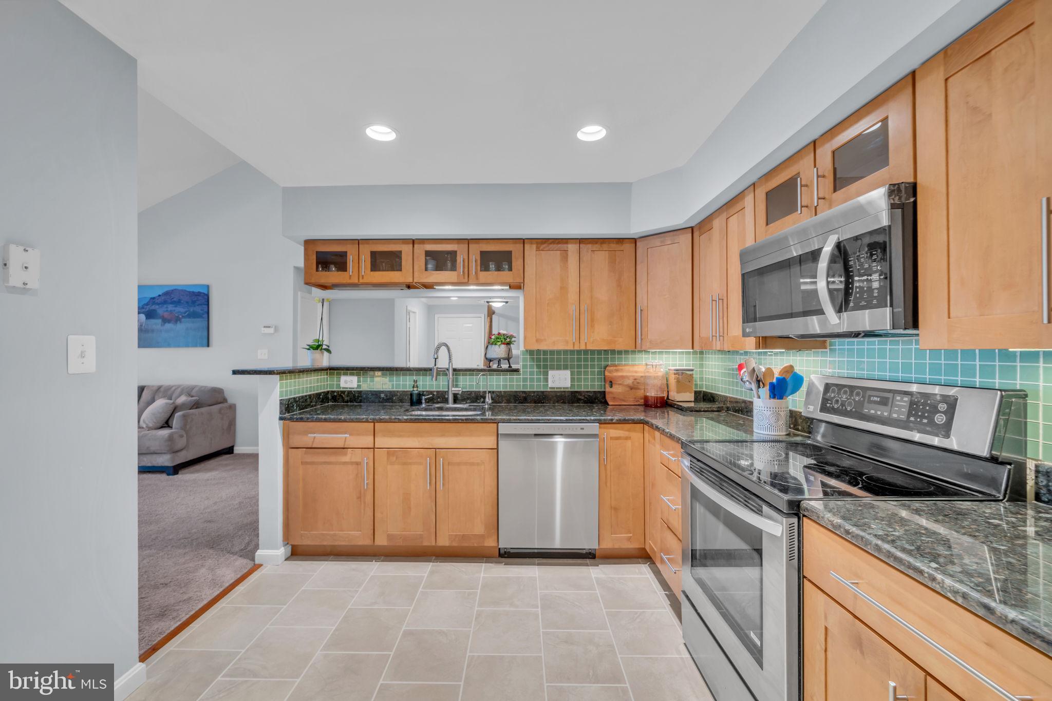 2233 Lovedale Lane, Unit L Reston, VA 20191 - Photo 10 of 18 a kitchen with stainless steel appliances granite countertop a stove a sink and a microwave
