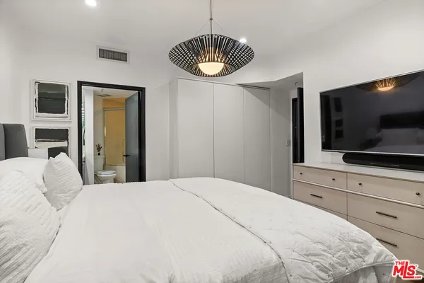 a bedroom with a bed and a flat screen tv