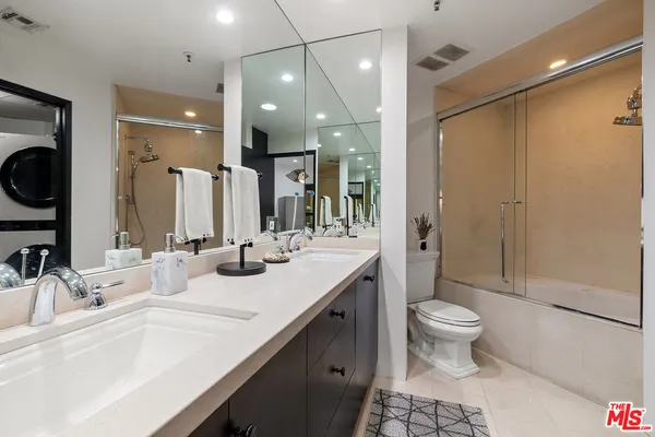 a bathroom with a double vanity sink toilet and shower