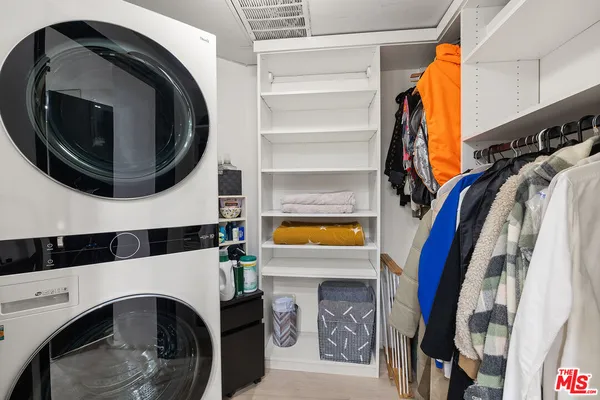 a view of walk in closet with clothes and shoes