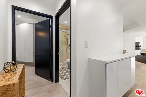 a bedroom with a bed and a lamp on dresser