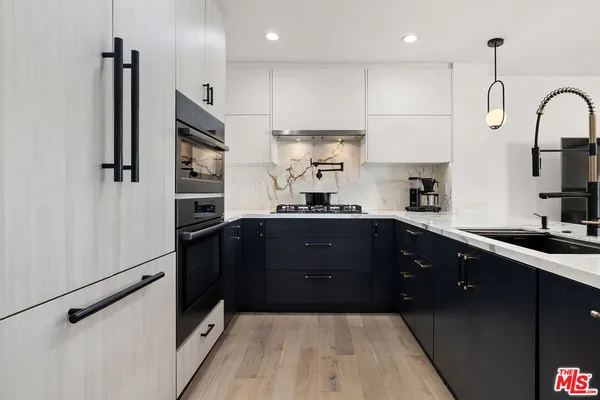 a kitchen with stainless steel appliances a refrigerator sink and cabinets