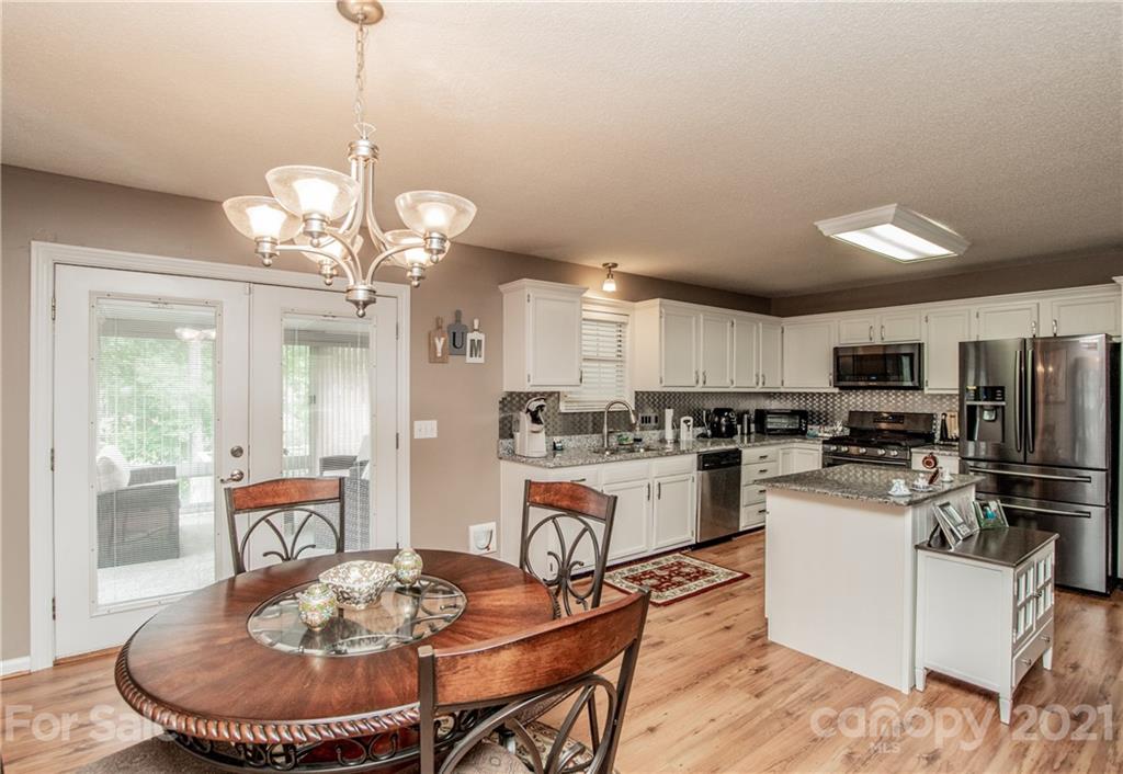 1360 Mistletoe Ridge Place Northwest Concord, NC 28027 - Photo 15 of 38 a kitchen with a dining table and chairs