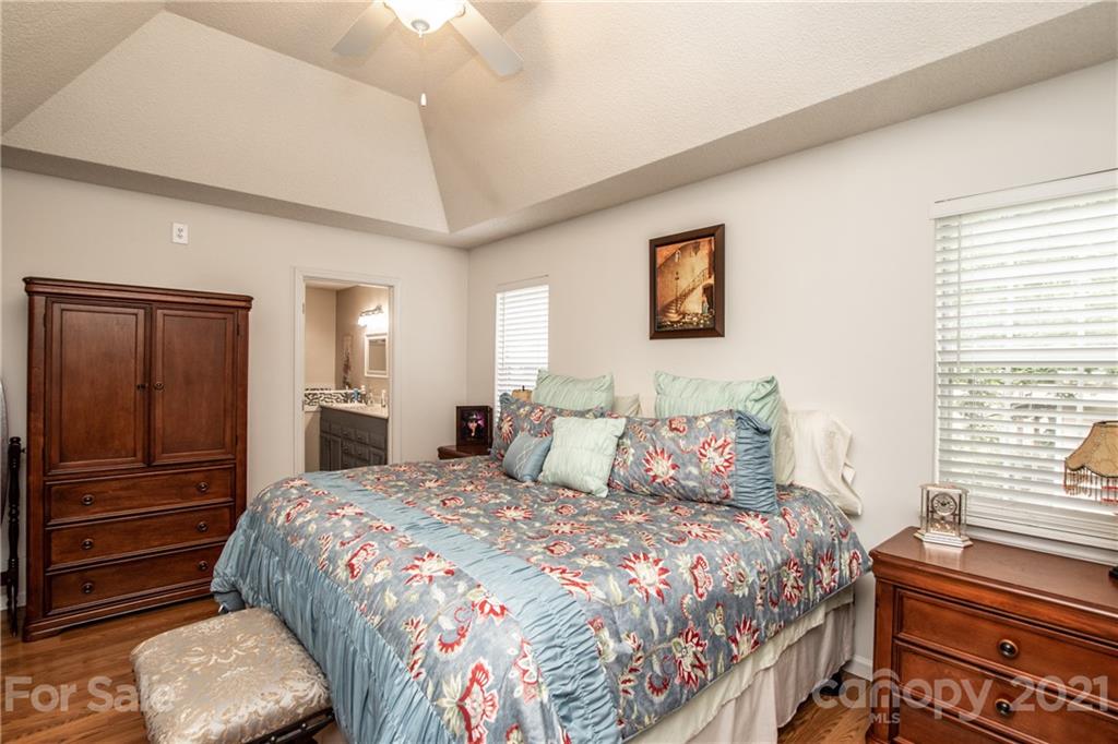 1360 Mistletoe Ridge Place Northwest Concord, NC 28027 - Photo 19 of 38 a bedroom with a bed and dresser with mirror