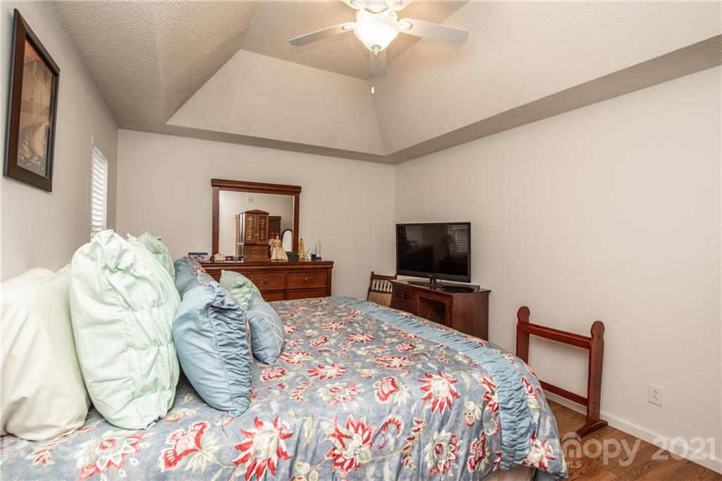 1360 Mistletoe Ridge Place Northwest Concord, NC 28027 - Photo 21 of 38 a bedroom with a bed and a flat screen tv