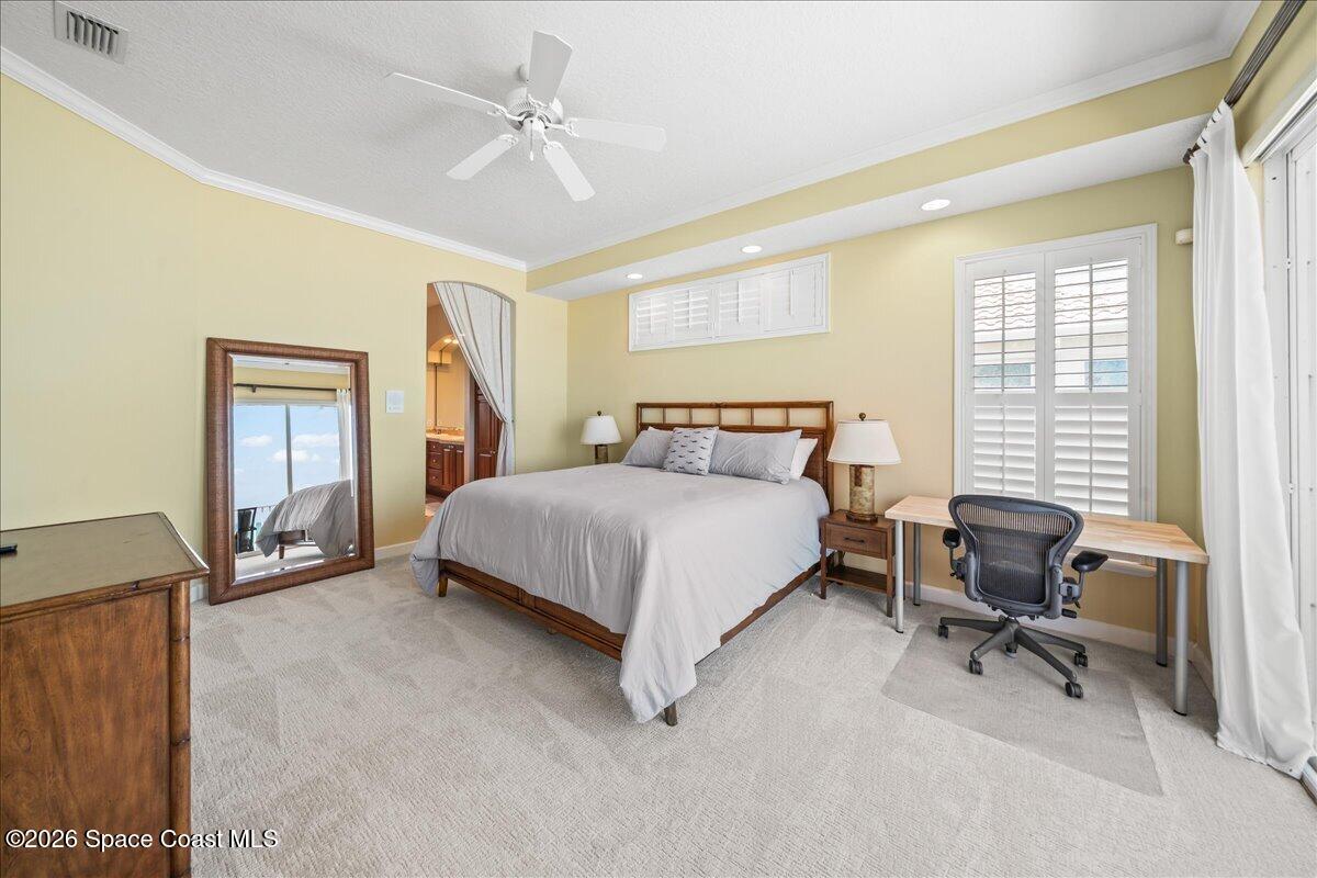 7585 South Hwy A1A Melbourne Beach, FL 32951 - Photo 17 of 45 a bedroom with a bed a chair and a chandelier