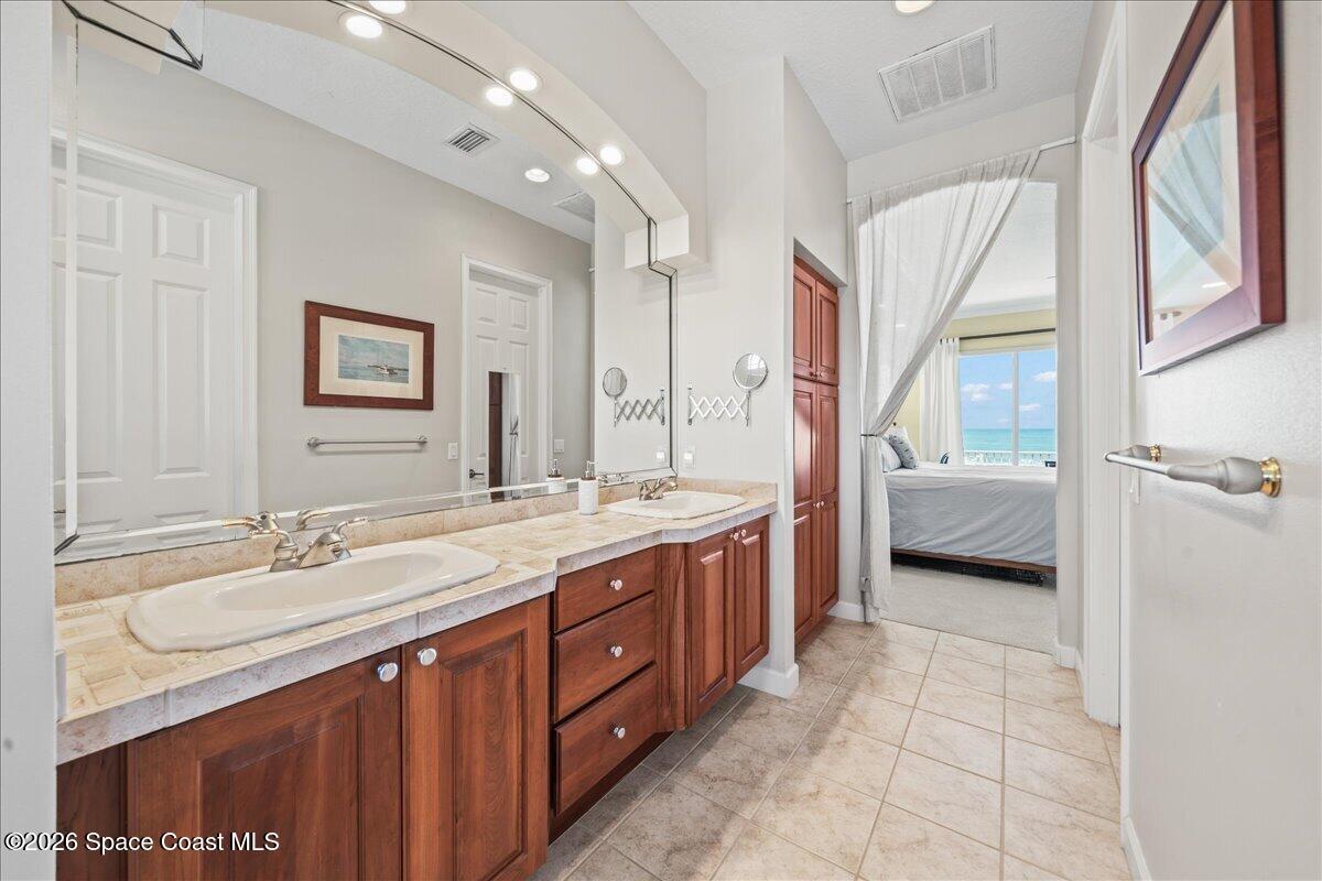7585 South Hwy A1A Melbourne Beach, FL 32951 - Photo 18 of 45 a en suite bathroom with a double vanity sink a mirror and a shower