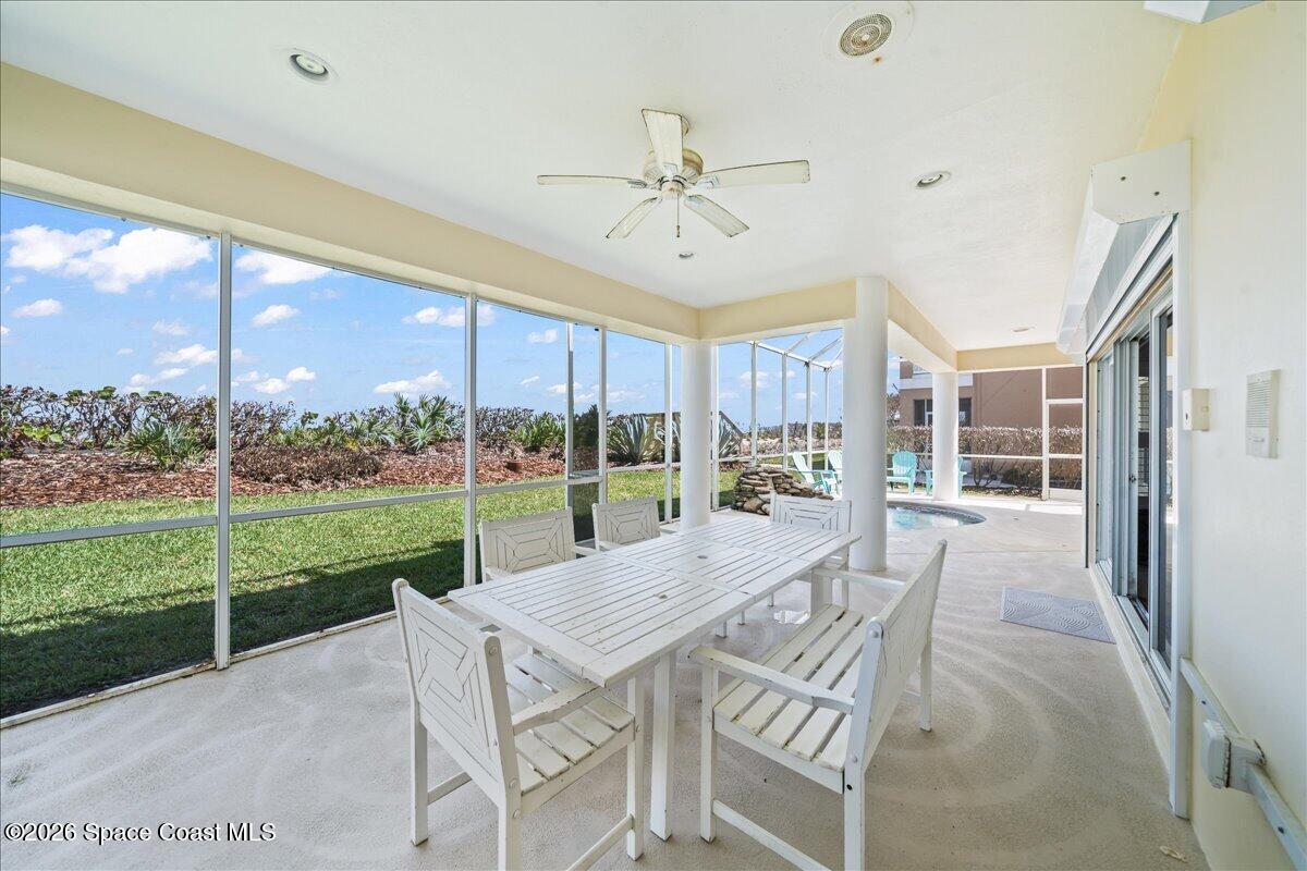 7585 South Hwy A1A Melbourne Beach, FL 32951 - Photo 33 of 45 a view of a patio with a table chairs and a floor to ceiling window