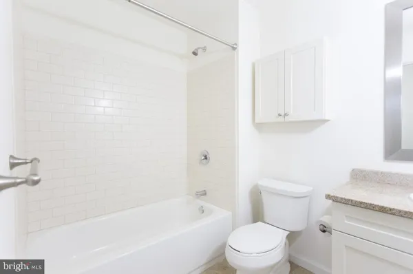 a white toilet sitting next to a bath tub