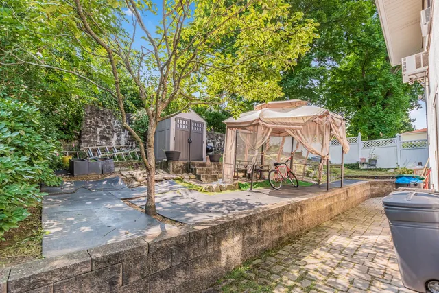 a backyard of a house with plants and tree