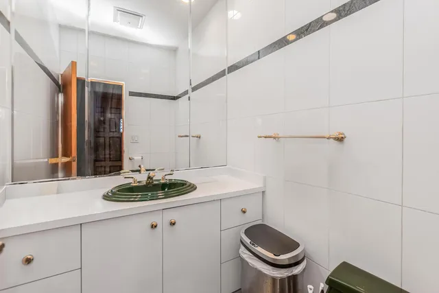 a kitchen with stainless steel appliances granite countertop a stove top oven a sink dishwasher and white cabinets with wooden floor