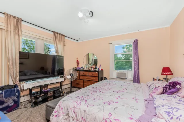 a hallway with wooden floor chandelier and living room