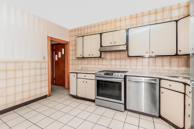 a kitchen with stainless steel appliances a refrigerator sink and cabinets
