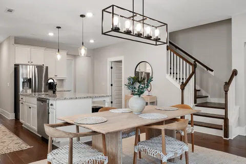 a kitchen with stainless steel appliances kitchen island a dining table and chairs