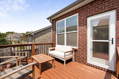 a view of a house with wooden deck and furniture