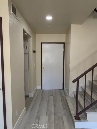 a view of a hallway with wooden floor and entryway
