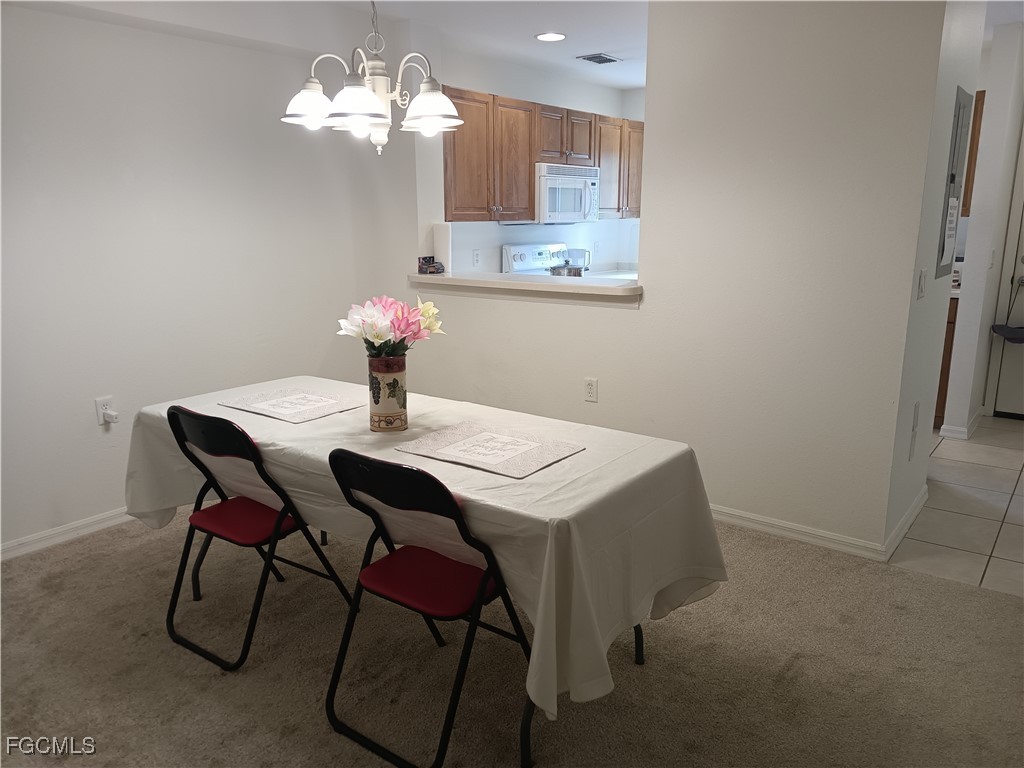 9410 Ivy Brook Run, Unit 206 Fort Myers, FL 33913 - Photo 13 of 16 a view of a dining room with furniture and chandelier