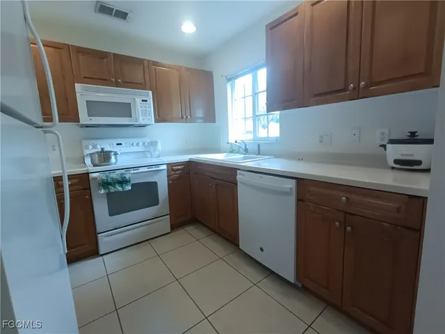 a kitchen with a sink stove top oven and cabinets