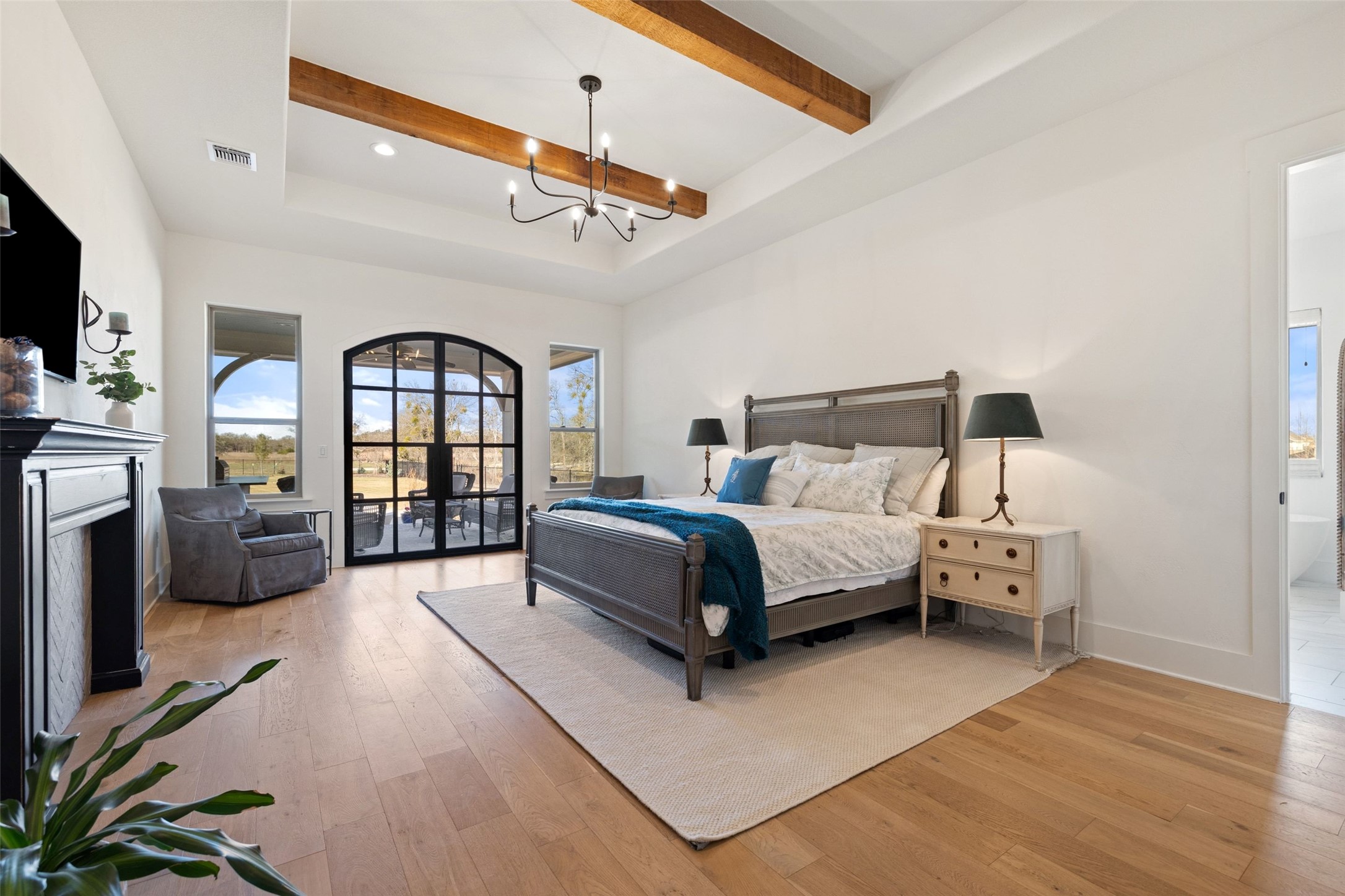 105 Deer Valley Road Georgetown, TX 78628 - Photo 14 of 40 Bedroom featuring a fireplace, access to exterior, light wood-type flooring, beamed ceiling, and french doors