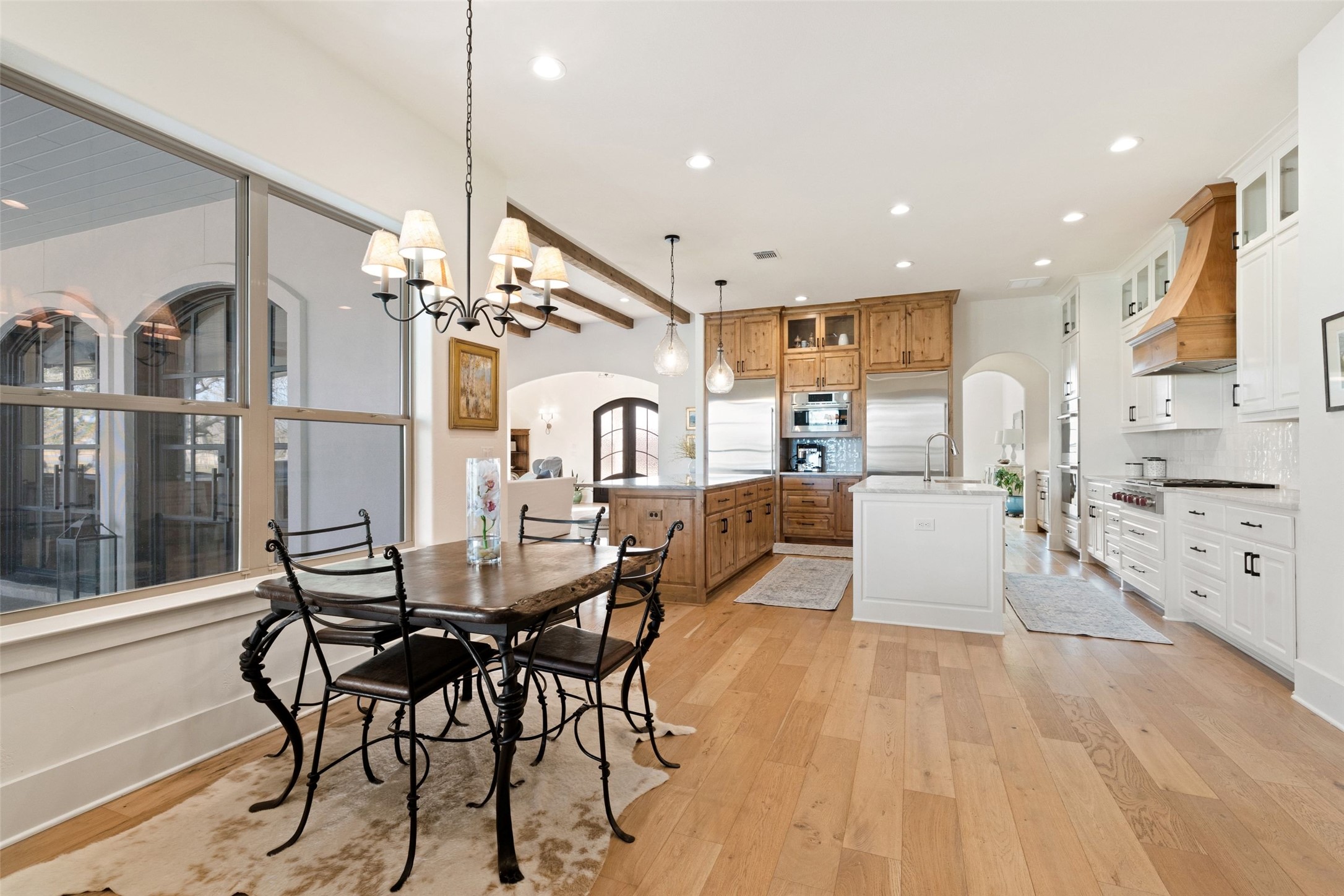 105 Deer Valley Road Georgetown, TX 78628 - Photo 24 of 40 Dining space featuring arched walkways, light wood-style floors, hanging lights, and beam ceiling