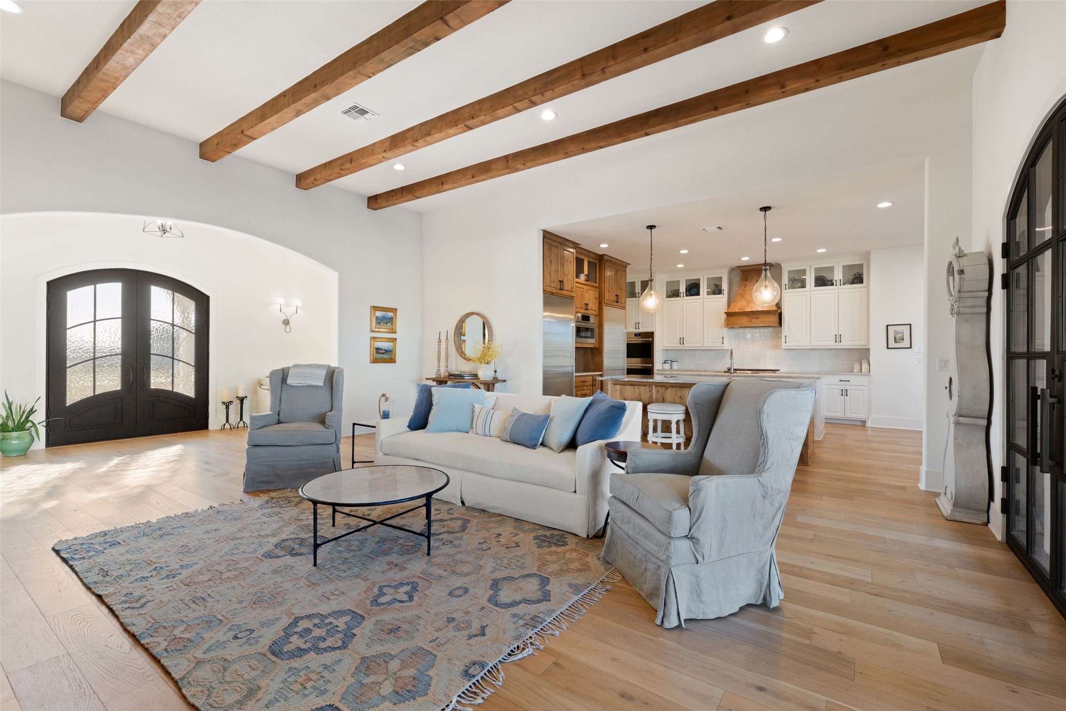 105 Deer Valley Road Georgetown, TX 78628 - Photo 7 of 40 Living room with arched walkways, french doors, beam ceiling, recessed lighting, and light wood finished floors