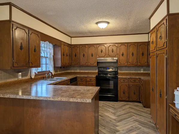 a kitchen with granite countertop a stove and cabinets