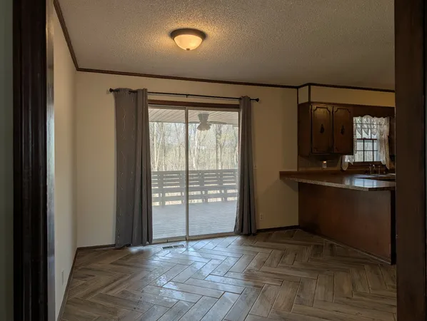 a view of an empty room with a fireplace and a window