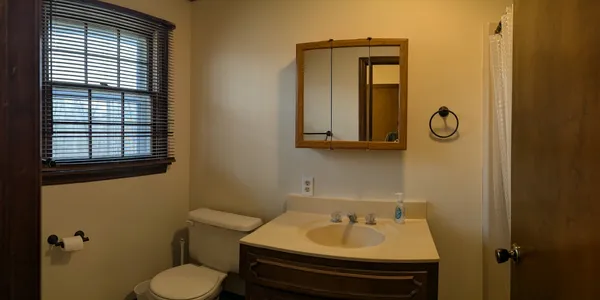 a bathroom with a sink toilet and mirror