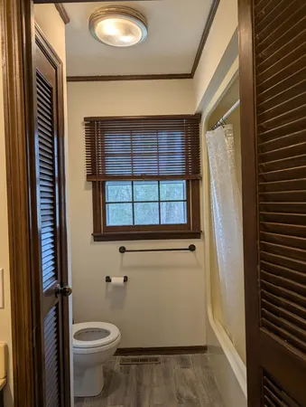 a bathroom with a toilet and a shower curtain