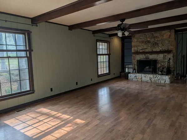 an empty room with windows and fireplace