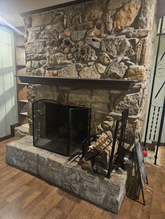 a living room with a fireplace wooden floor and a window