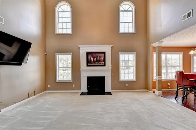a bed sitting in a bedroom next to a window with a flat tv screen and dresser