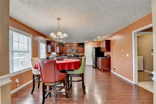 a view of a livingroom with a chandelier fan and windows