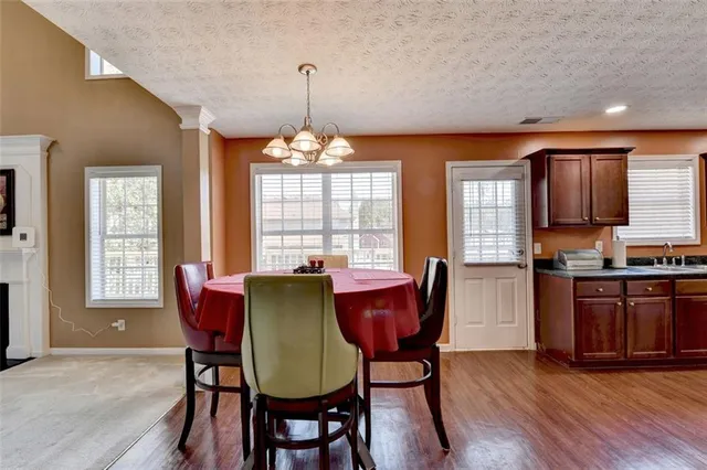 a view of an empty room with window and chandelier