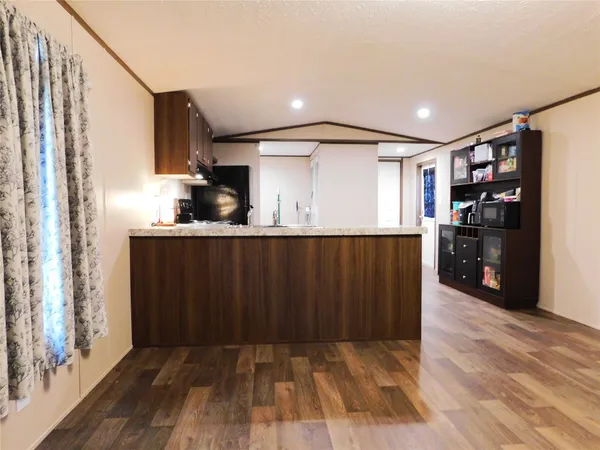 a kitchen with granite countertop a refrigerator and a stove top oven