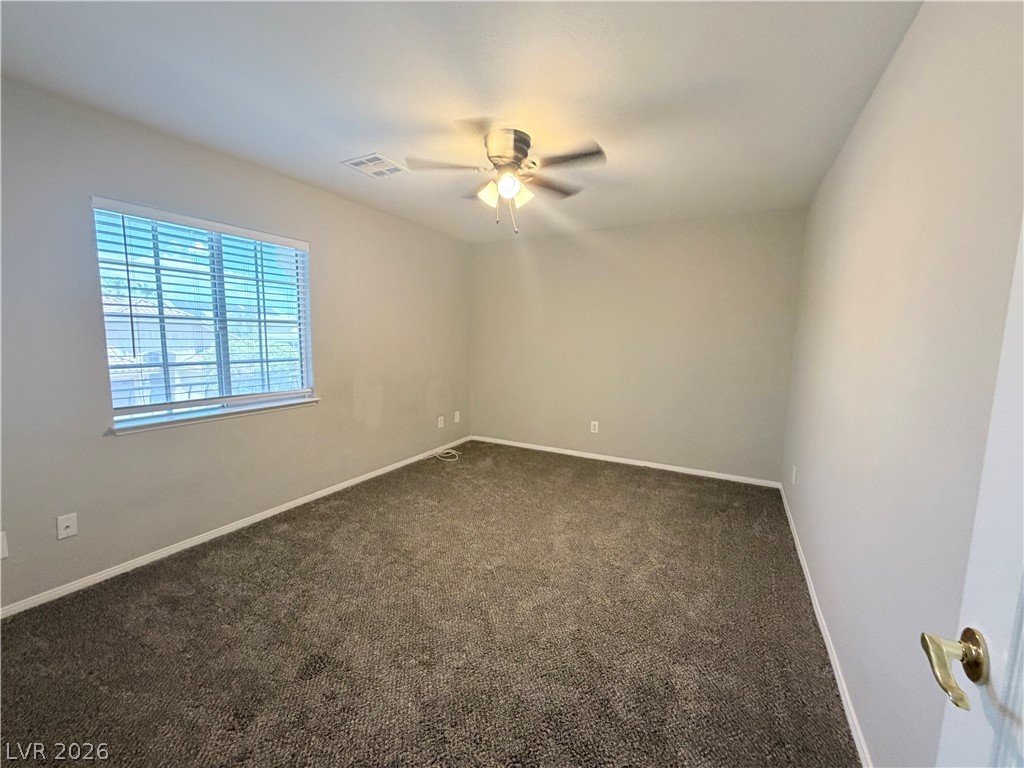 6116 Rabbit Track Street Las Vegas, NV 89130 - Photo 15 of 28 A well-lit bedroom provides comfort and style, complete with a ceiling fan and plush carpet.