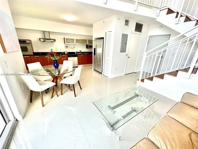 a living room with furniture and kitchen view