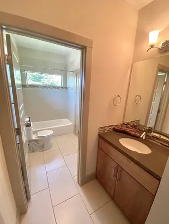 a bathroom with a granite countertop sink and a mirror