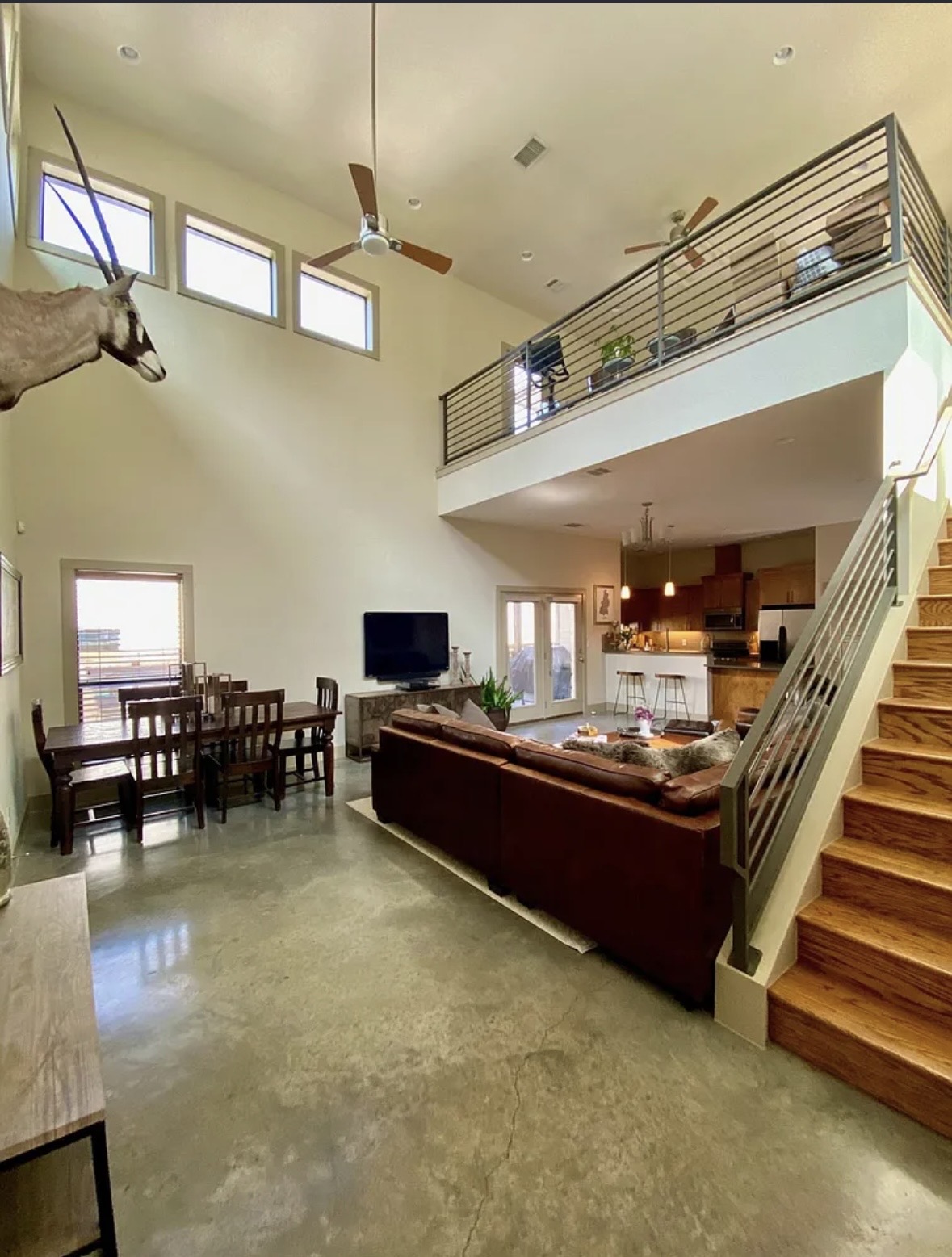 903 Cardinal Lane, Unit A Austin, TX 78704 - Photo 3 of 23 Living room with finished concrete flooring, ceiling fan, plenty of natural light, and a high ceiling