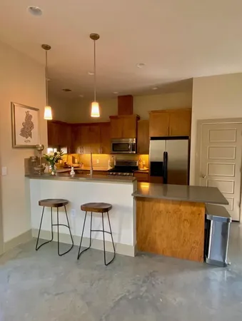 a kitchen with stainless steel appliances granite countertop a sink a stove and a refrigerator