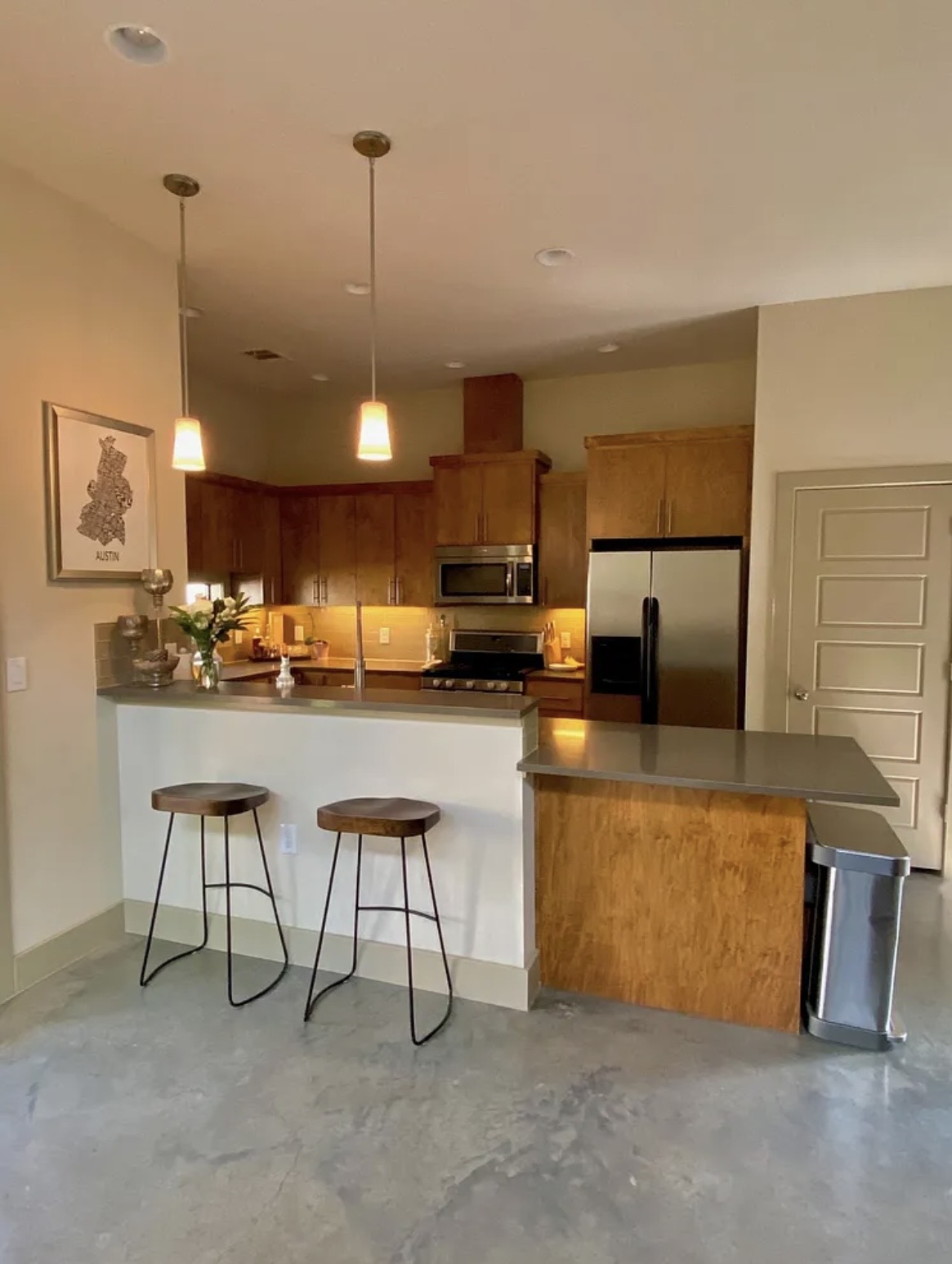 903 Cardinal Lane, Unit A Austin, TX 78704 - Photo 7 of 23 Kitchen with wood finish cabinetry, stainless steel appliances, a breakfast bar, a peninsula, and concrete flooring
