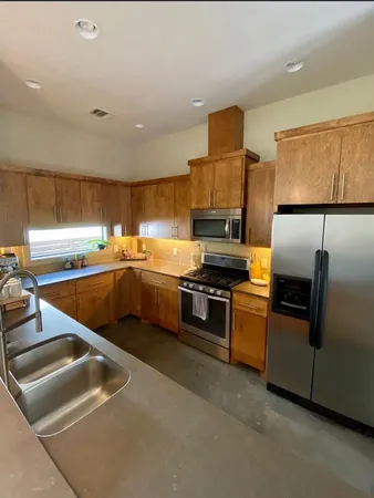 a kitchen with a sink a counter top space stainless steel appliances and a window
