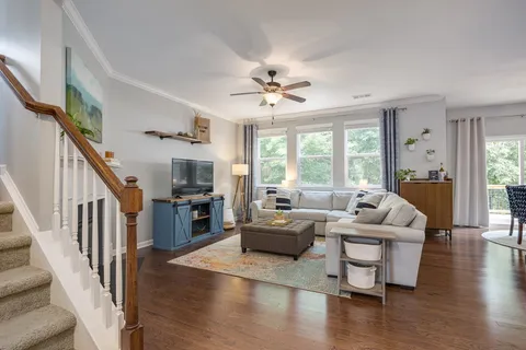 a large kitchen with stainless steel appliances granite countertop a stove refrigerator and a wooden floor