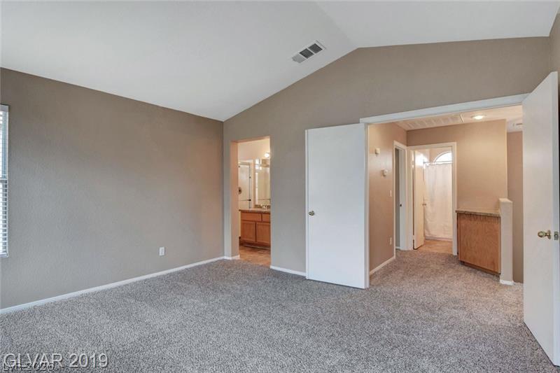 2647 Ridgewater Circle Henderson, NV 89074 - Photo 15 of 26 Vaulted ceilings and soft carpeting create a comfortable atmosphere in this main bedroom suite.
