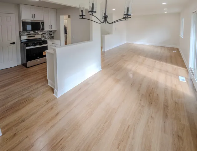 a kitchen view with wooden floor and a stove top oven