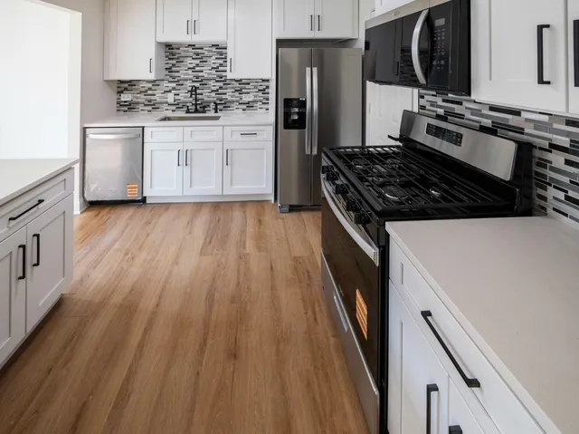 a kitchen with wooden floor and a stove top oven