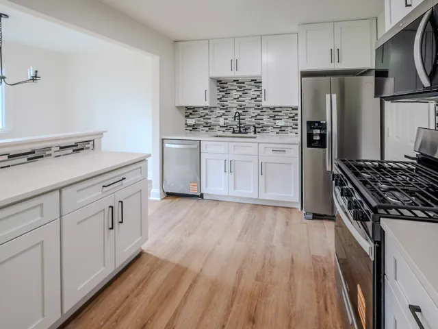 a kitchen with white cabinets and appliances