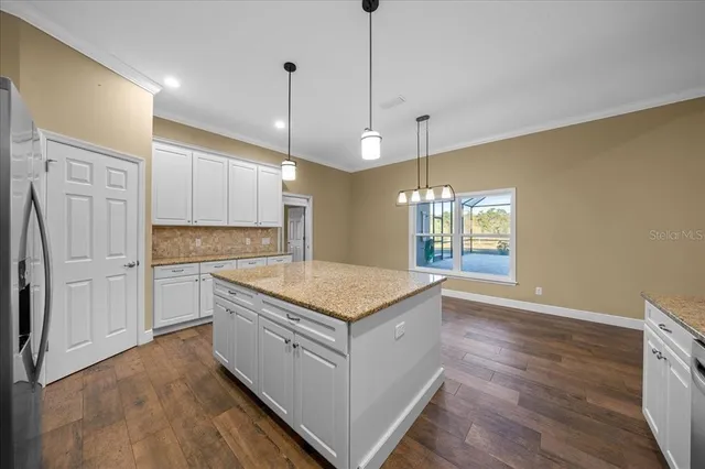 a kitchen with counter top space and wooden floor