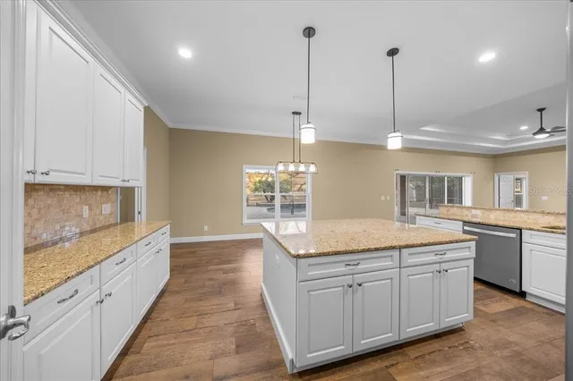 a large kitchen with white cabinets and stainless steel appliances
