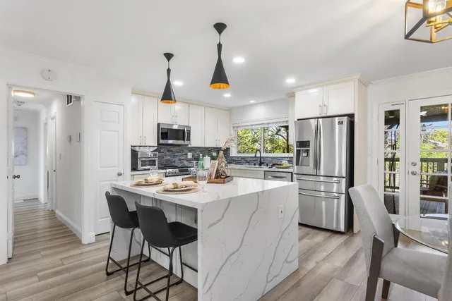 a kitchen with stainless steel appliances a dining table and chairs
